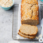 Healthy vegan oat and coconut loaf bread, cake on a cooling rack Grey stone background Copy space